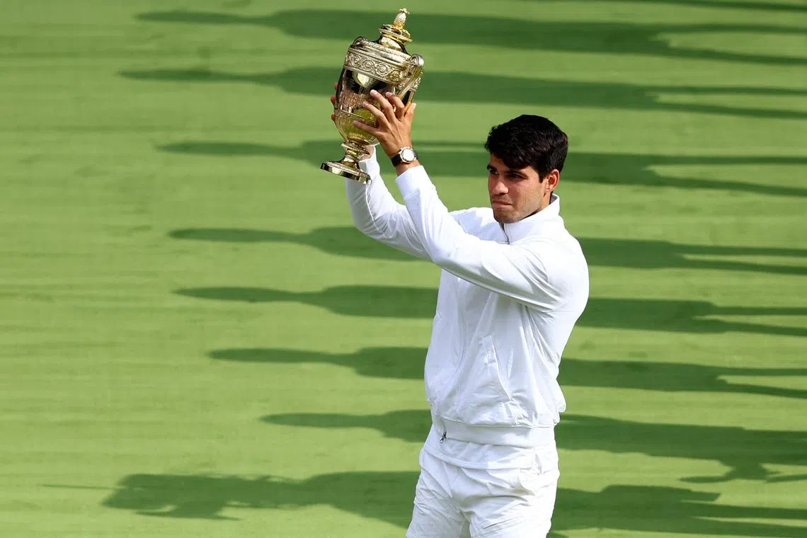 Tennis - Wimbledon - All England Lawn Tennis and Croquet Club, London, Britain - July 14, 2024 Spain's Carlos Alcaraz with the trophy after winning the men's singles final against Serbia's Novak Djokovic REUTERS/Matthew Childs
