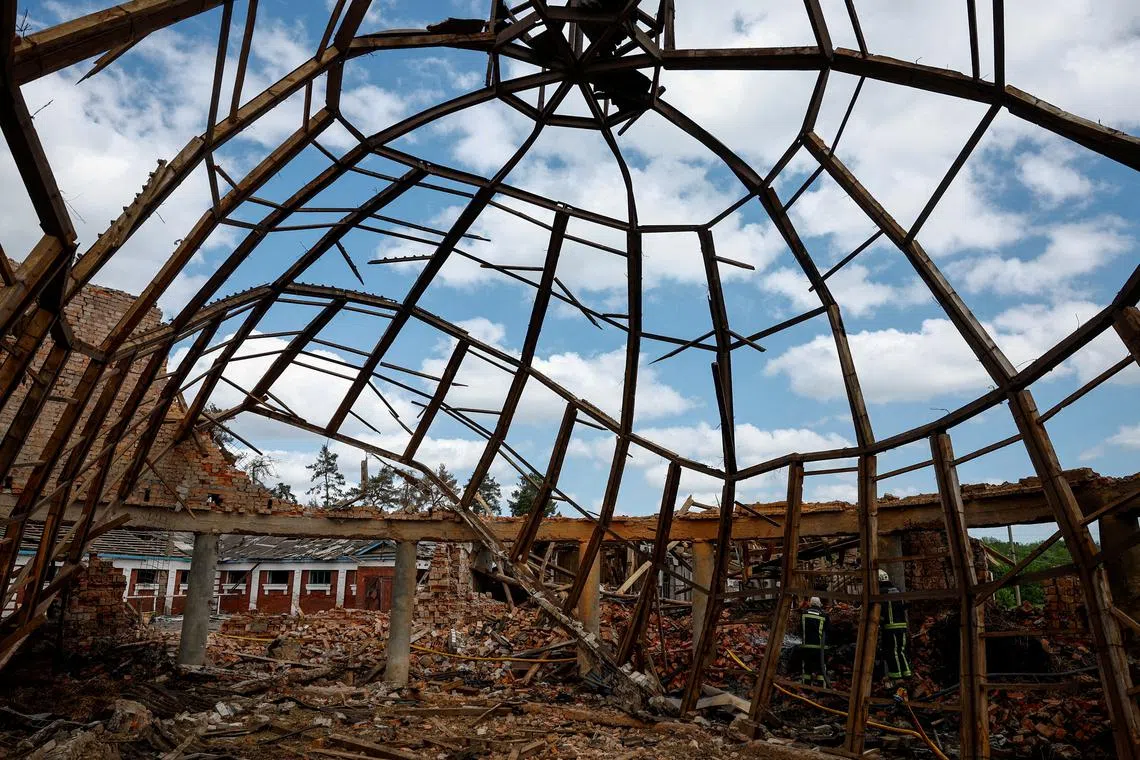 Firefighters at the site of a school damaged by Russian missile strikes. Outside Kharkiv, Ukraine May 30, 2024. REUTERS/Valentyn Ogirenko