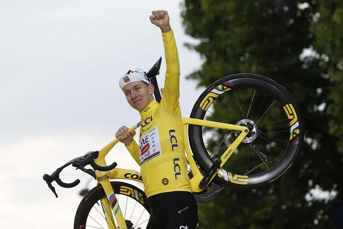 FILE PHOTO: Cycling - Tour de France - Stage 21 - Mantes-la-Ville to Paris - Paris, France - July 27, 2025 UAE Team Emirates XRG's Tadej Pogacar celebrates on the podium with his bike while wearing the yellow jersey after winning the Tour de France REUTERS/Benoit Tessier/File Photo