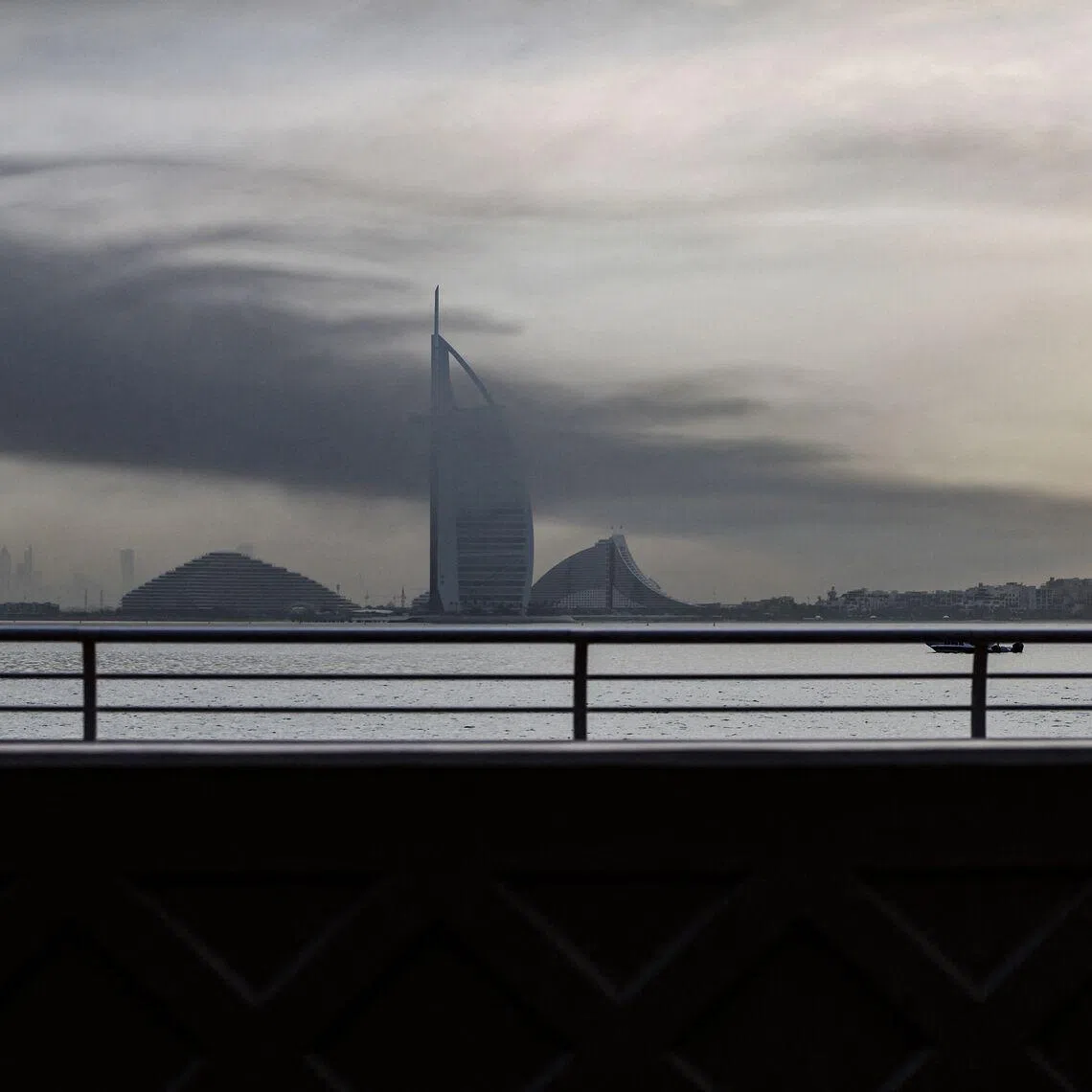 Smoke rises above Dubai on March 13, 2026. Explosions rattled buildings in Dubai and a large cloud of smoke hung over a central area of the Middle East financial hub on March 13, AFP correspondents said. (Photo by AFP) / 