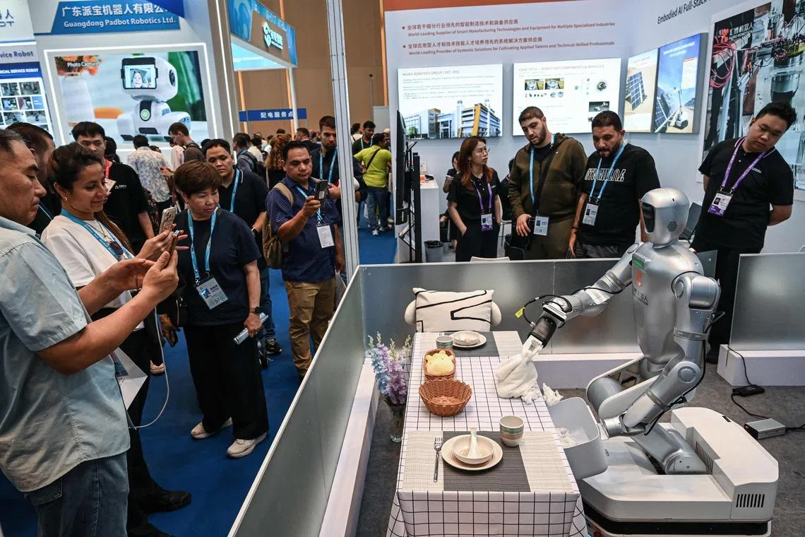 TOPSHOT - A robot from Huibo Robotics is pictured cleaning a desk at the 139th edition of the China Import and Export Fair, also known as the Canton Fair, in Guangzhou in southern China's Guangdong province on April 15, 2026. (Photo by Jade GAO / AFP)