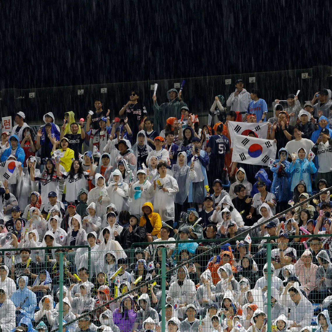 Asian Games - Aichi-Nagoya 2026 - Baseball - Gold Medal Match - South Korea v Japan - Toyohashi Municipal Baseball Stadium, Toyohashi, Japan - September 27, 2026  Fans wear rain ponchos in the stands REUTERS/Eloisa Lopez