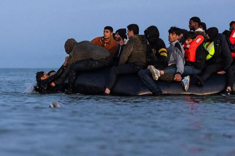 Migrants try to board a smuggler's boat in an attempt to cross the English Channel off the beach of Gravelines, northern France.