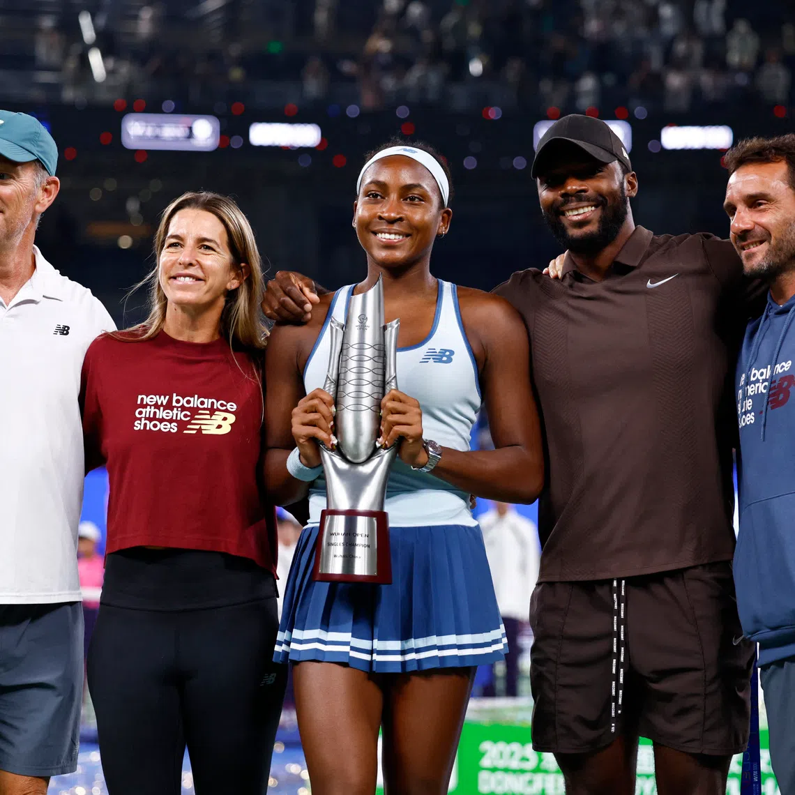 Tennis - WTA 1000 - Wuhan Open - Optics Valley International Tennis Center, Wuhan, China - October 12, 2025 Coco Gauff of the U.S. poses with the trophy and team after winning the final against Jessica Pegula of the U.S. REUTERS/Tingshu Wang