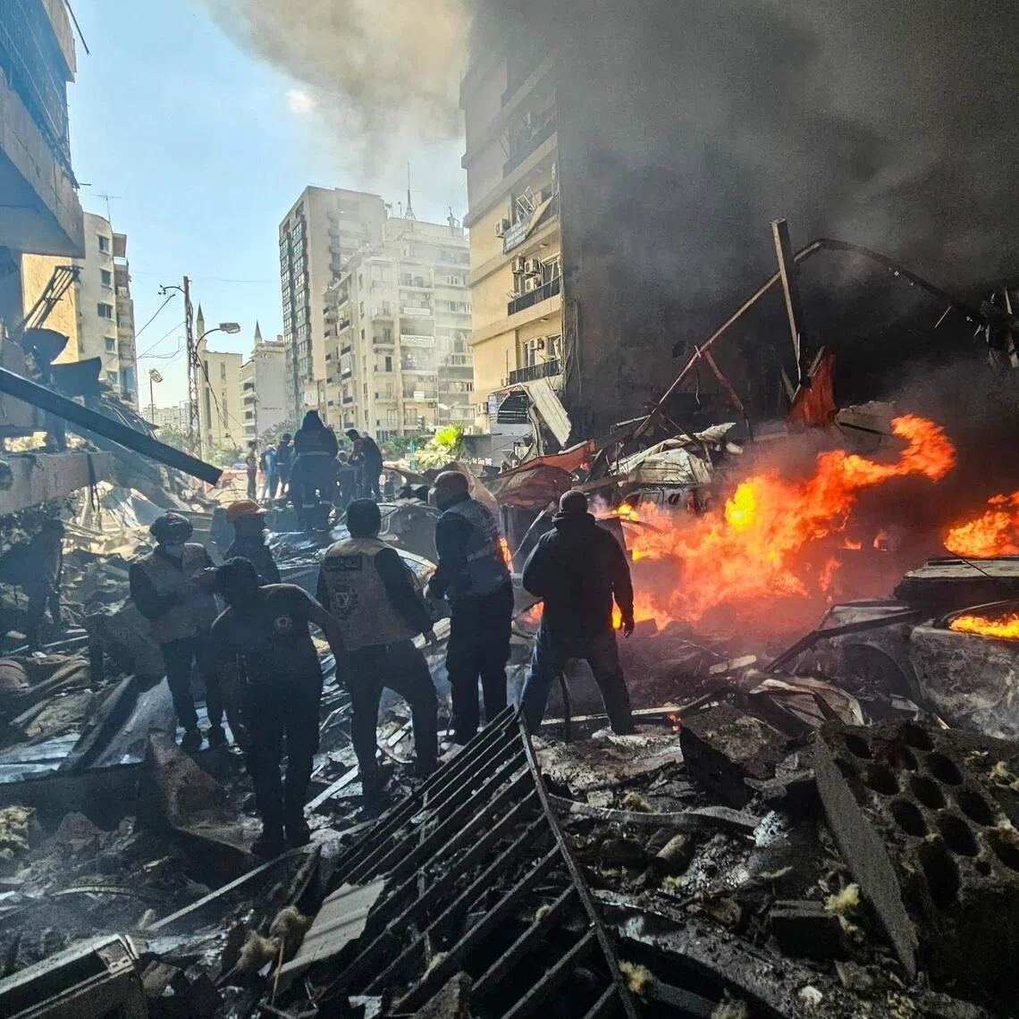 First responders standing amid rubble at the site of an Israeli airstrike in Beirut's Corniche al-Mazraa neighbourhood on April 8.