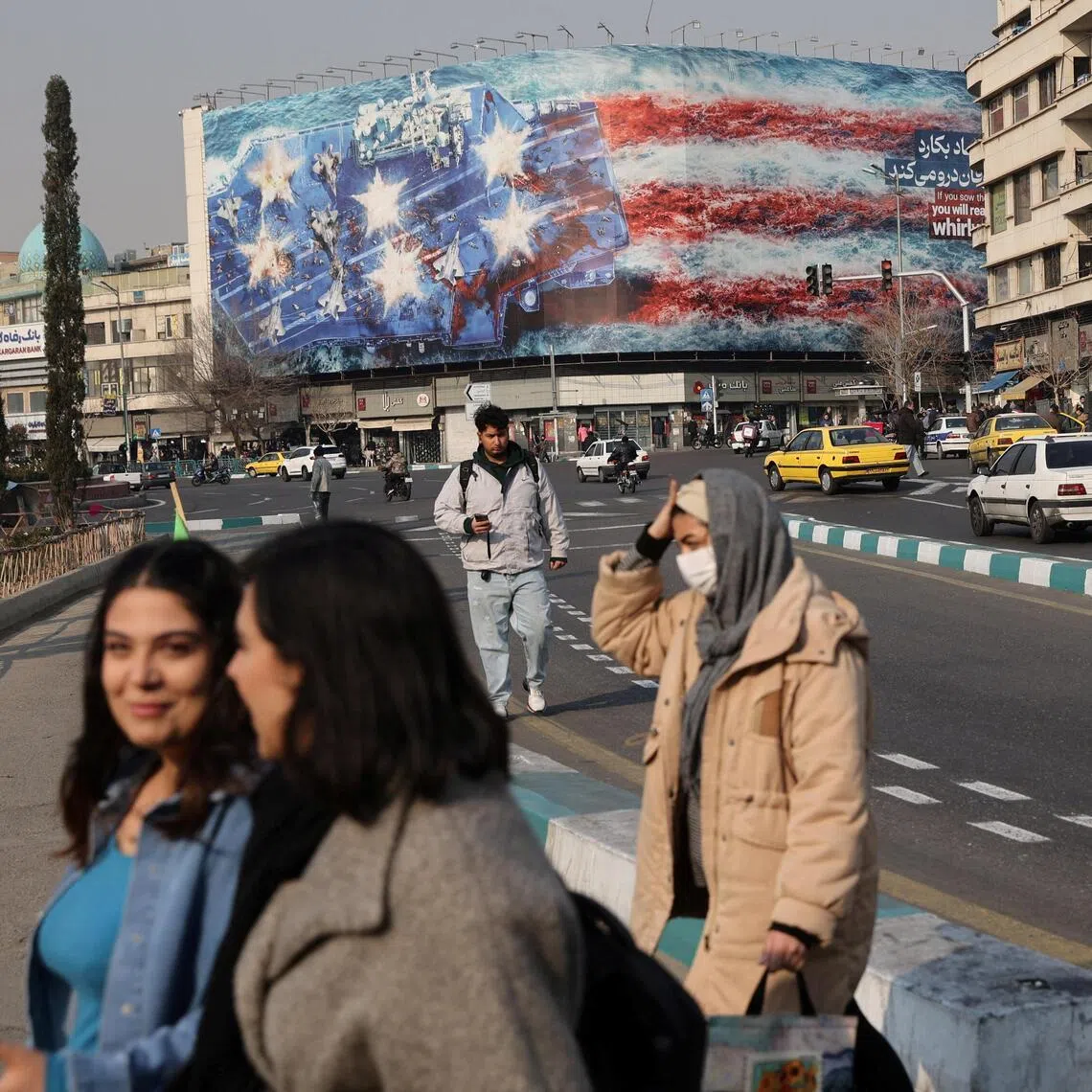 People walking past an anti-US billboard in Iran's capital, Tehran, on Jan 26.