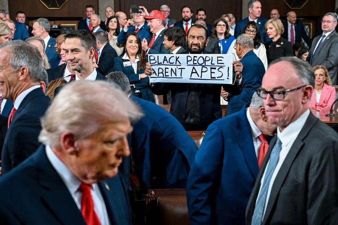 US Democratic Representative Al Green, of Texas, holds a "Black People Aren't Apes" sign as President Donald Trump arrives for a State of the Union address in the House Chamber of the US Capitol in Washington, DC, on Feb 24 