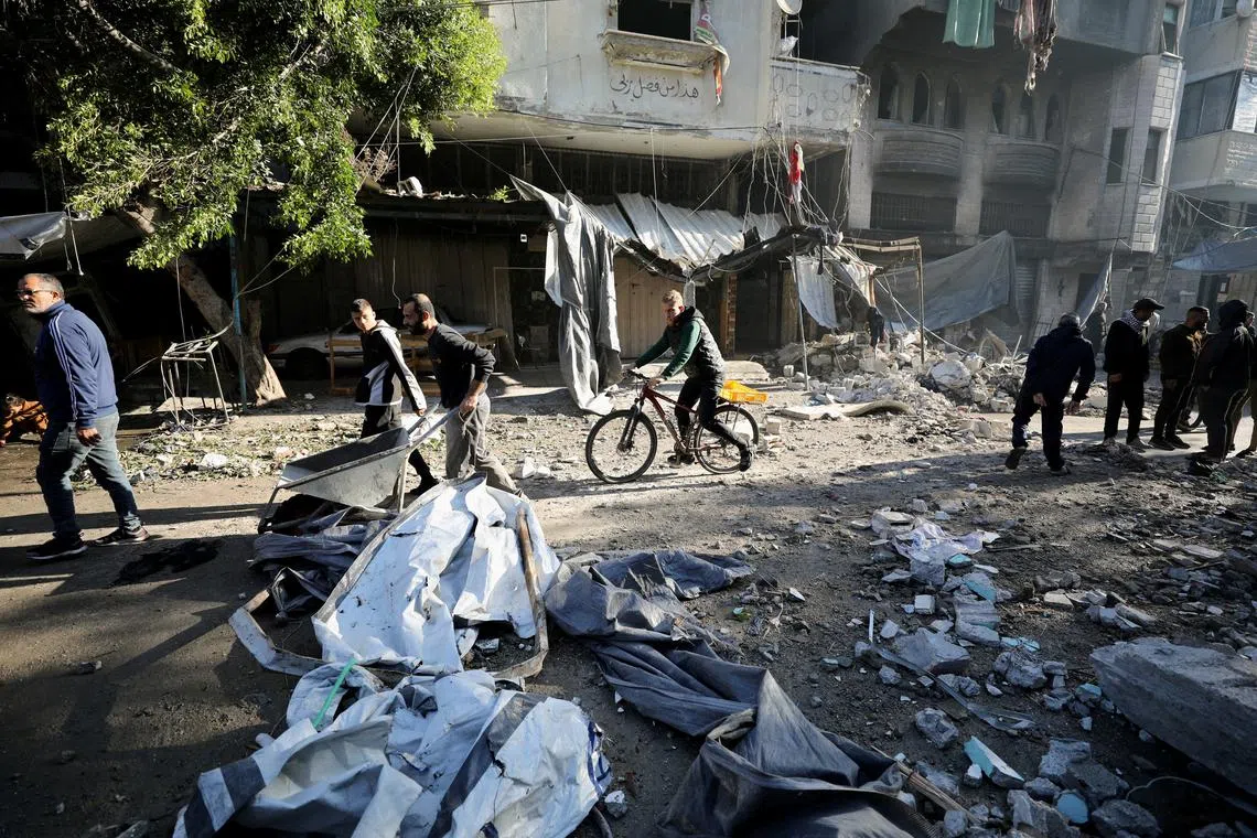 A Palestinian rides a bicycle amid rubble following an Israeli strike on a house, amid the ongoing conflict between Israel and Hamas, in Gaza City November 30, 2024. REUTERS/Dawoud Abu Alkas