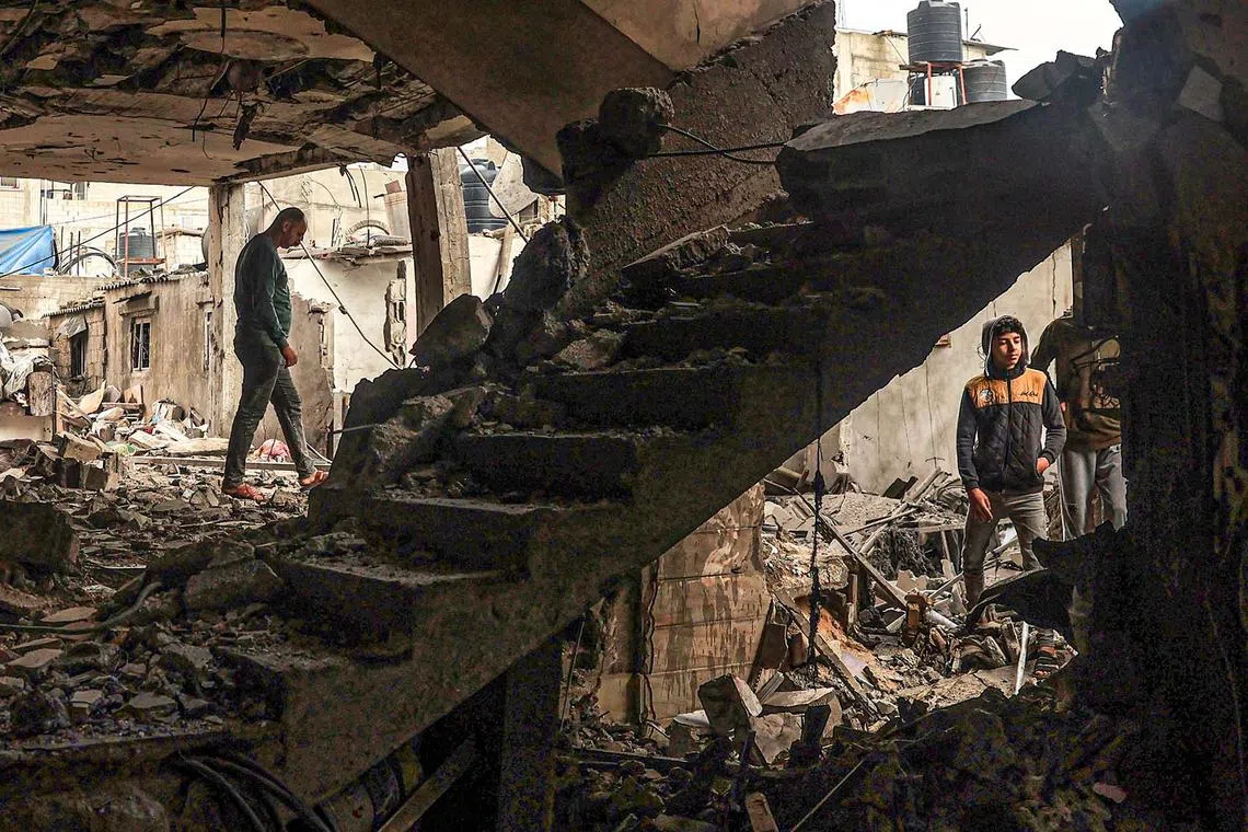 Palestinians checking the damages following Israeli bombardment in Rafah, in the southern Gaza Strip on Dec 14, 2023, amid ongoing battles between Israel and the Palestinian militant group Hamas. 