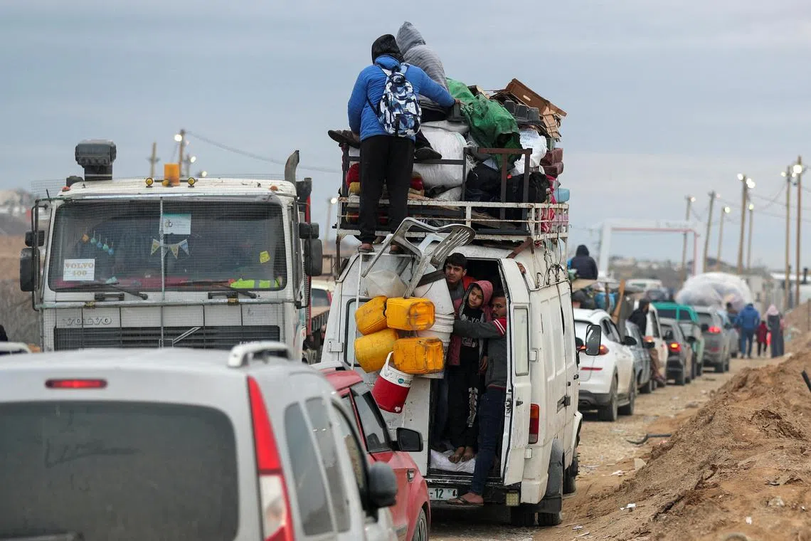 Palestinians wait to cross through a checkpoint run by U.S. and Egyptian security contractors after Israeli forces withdrew from the Netzarim Corridor, allowing people to travel in both directions between southern and northern Gaza, amid a ceasefire between Israel and Hamas, near Gaza City, February 9, 2025. REUTERS/Dawoud Abu Alkas     TPX IMAGES OF THE DAY     