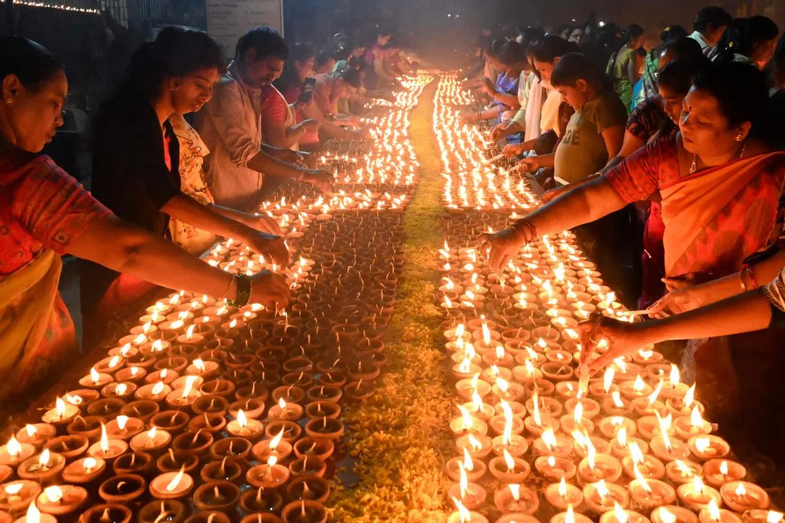 Devotees light traditional oil lamps as they celebrate the Hindu festival of 'Dev Deepawali' outside a temple in Hyderabad on November 7, 2022. 
