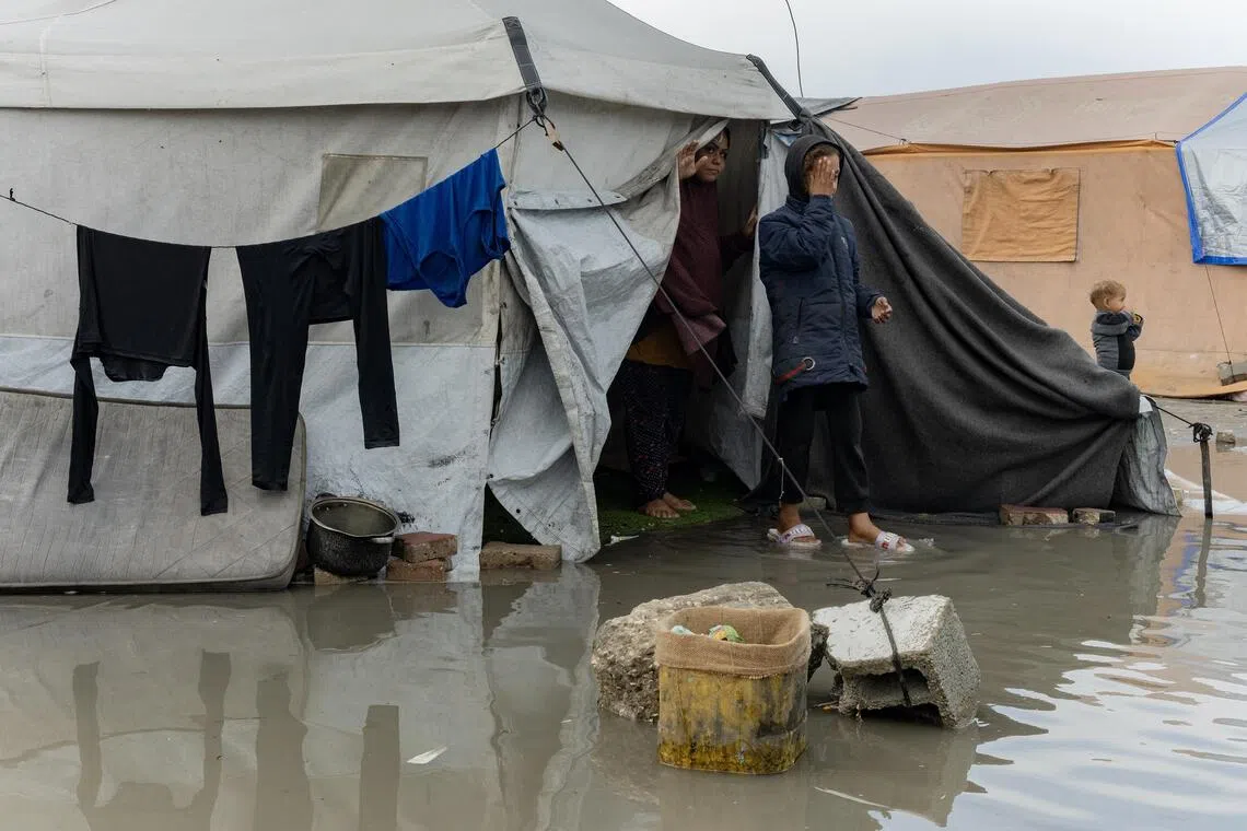 Cold rainwater reaches displaced Palestinians in a tent in Gaza City.