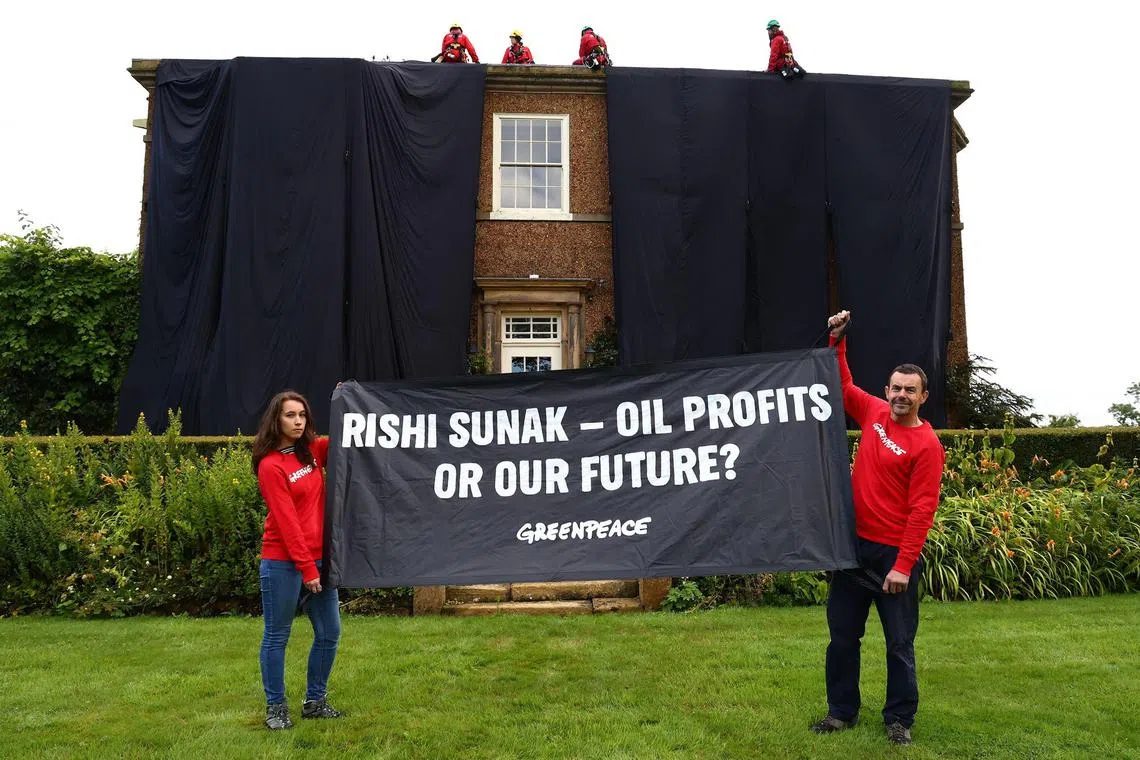 TOPSHOT - A handout picture taken and released by environmental action group Greenpeace on August 3, 2023 shows Greenpeace activists on the roof of Britain's Prime Minister Rishi Sunak's manor house in Kirby Sigston, northern England, to protest at his backing for new oil and gas licences in the North Sea. (Photo by Luca MARINO / Greenpeace United Kingdom / AFP) / RESTRICTED TO EDITORIAL USE - MANDATORY CREDIT "AFP PHOTO / GREENPEACE  / LUCA MARINO" - NO MARKETING NO ADVERTISING CAMPAIGNS - DISTRIBUTED AS A SERVICE TO CLIENTS --- NO ARCHIVE ---