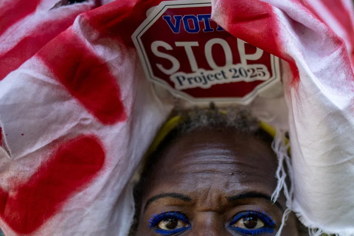 Activist Nadine Seiler of Maryland, wears a sign which reads, "Vote, Stop Project 2025," in reference to a set of conservative policy proposals, along the perimeter of the Republican National Convention in Milwaukee, Wisconsin, U.S., on July 17, 2024.  