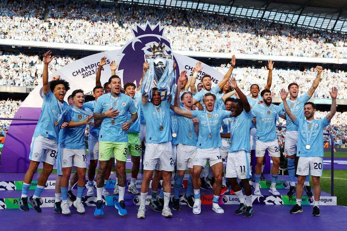 FILE PHOTO: Soccer Football - Premier League - Manchester City v West Ham United - Etihad Stadium, Manchester, Britain - May 19, 2024  Manchester City's Kyle Walker and teammates celebrate with the trophy after winning the Premier League REUTERS/Molly Darlington /File Photo