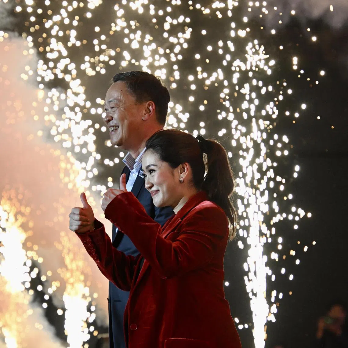 Pheu Thai party prime minister candidates Paethongtarn Shinawatra (foreground) and Srettha Thavisin greeting the crowd at a rally in Nonthaburi, Bangkok, on May 12, 2023. 