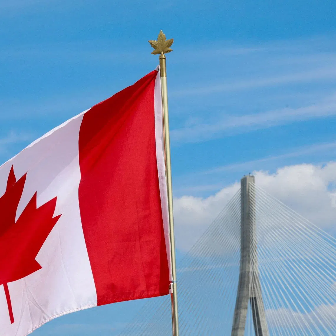 A Canadian flag flies near the Gordie Howe bridge connecting Windsor, Ontario, Canada, with Detroit, Michigan, U.S., ahead of its opening, in Windsor, Ontario, Canada, July 24, 2026.  REUTERS/Carlos Osorio