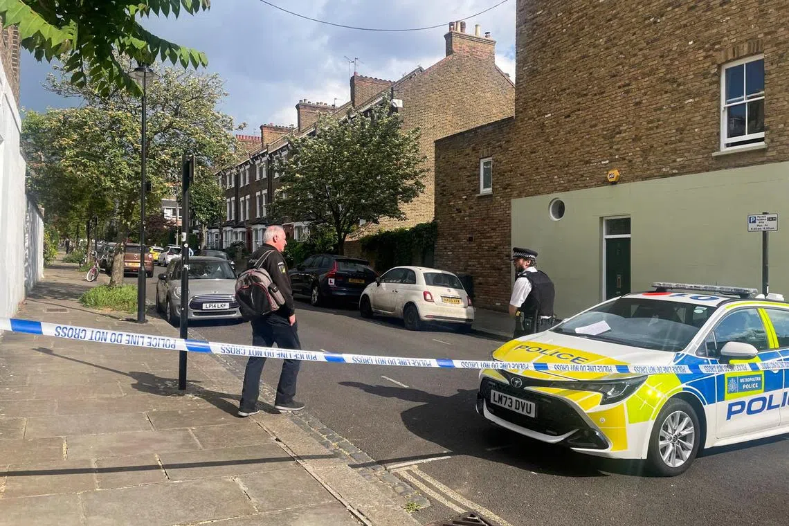 A person walks to a police officer at a cordoned off street, where a fire broke out at Britain's Prime Minister Keir Starmer's home in the early hours of Monday, in north London, Britain, May 12, 2025. REUTERS/Paul Sandle