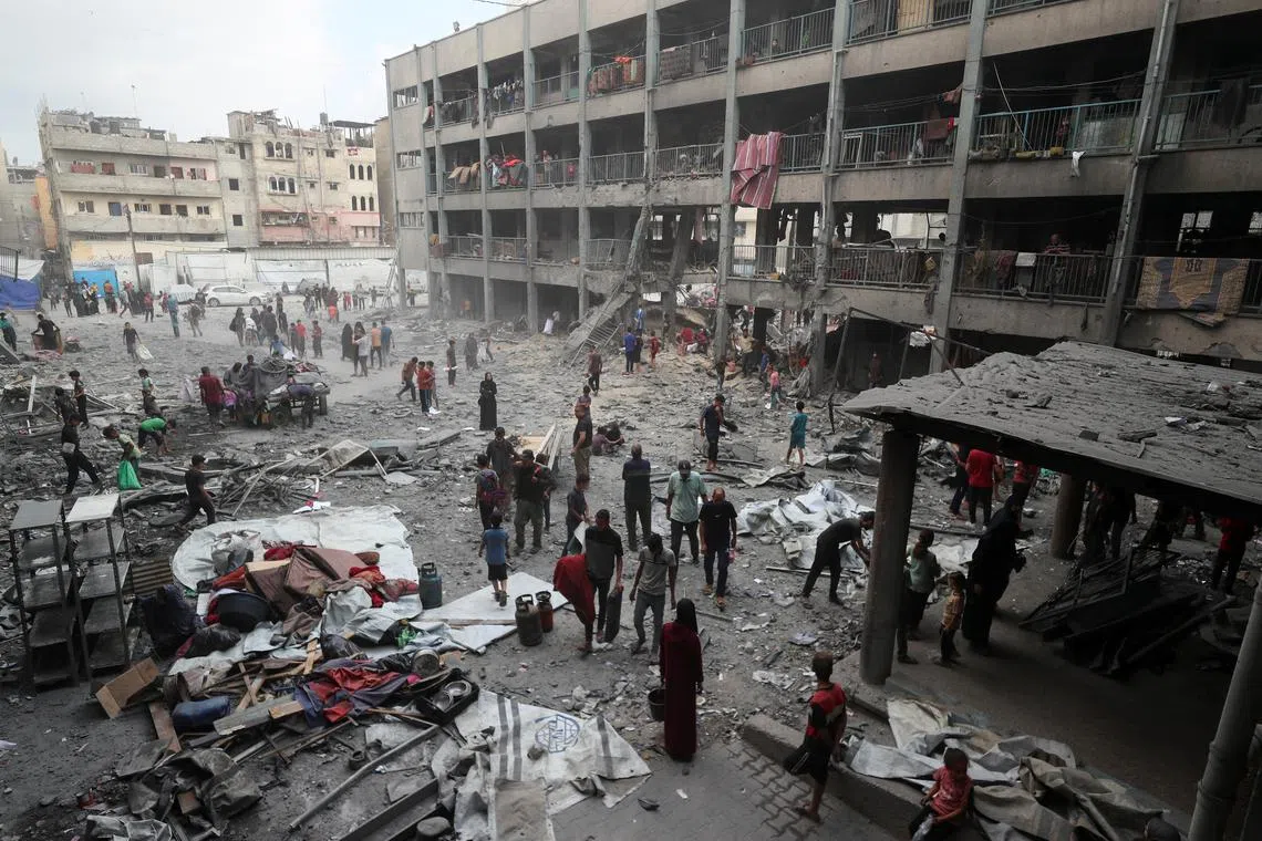 Palestinians inspect the damage at an UNRWA school sheltering displaced people that was hit in an Israeli air strike on Sunday, in Gaza City, June 30, 2025. REUTERS/Mahmoud Issa