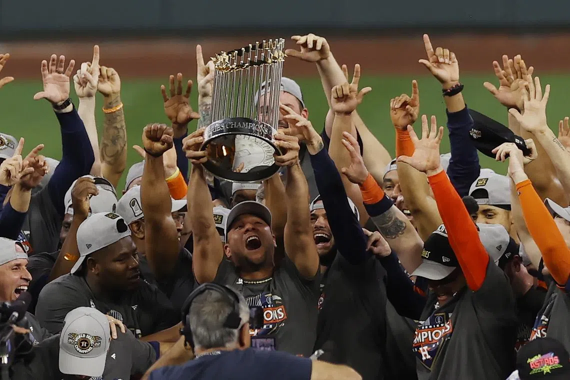 The Houston Astros players celebrating with the Commissioner's Trophy after defeating the Philadelphia Phillies to clinch the World Series 4-2 on Saturday. 