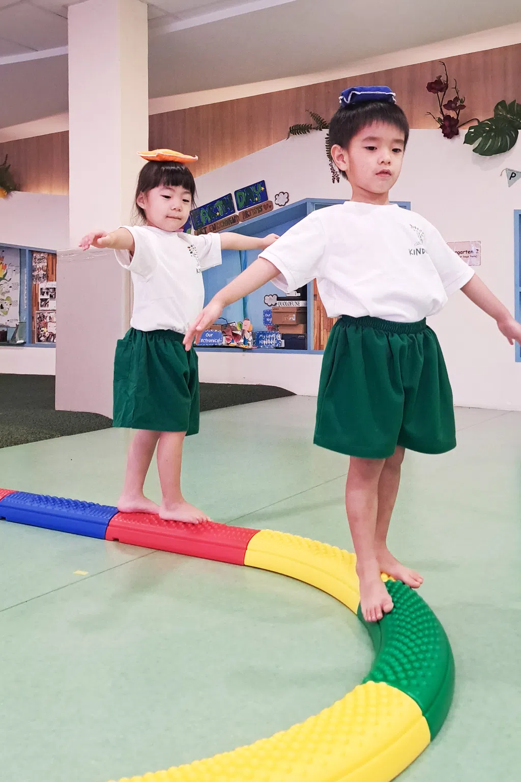 Kinderland students balancing on toys 