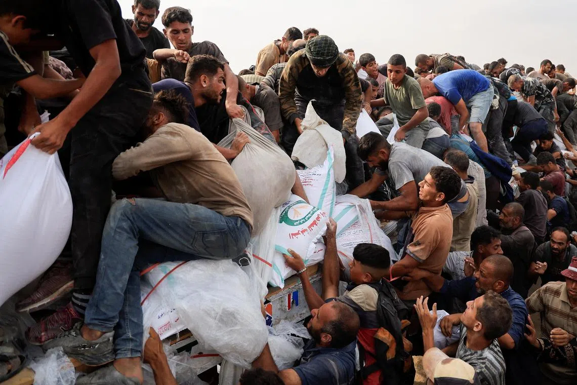 A desperate mob scrambles to get aid from trucks that entered Gaza through Israel in Khan Younis city.