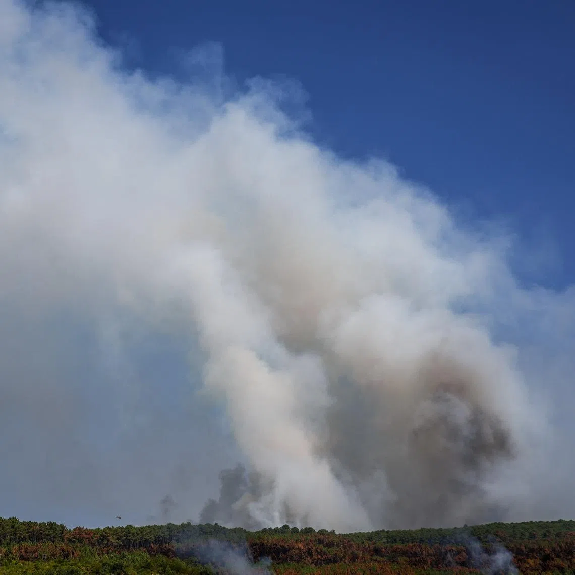 Smoke rises from a wildfire in Le Grand Crohot amid drought conditions following a heatwave and water shortages across much of France.
