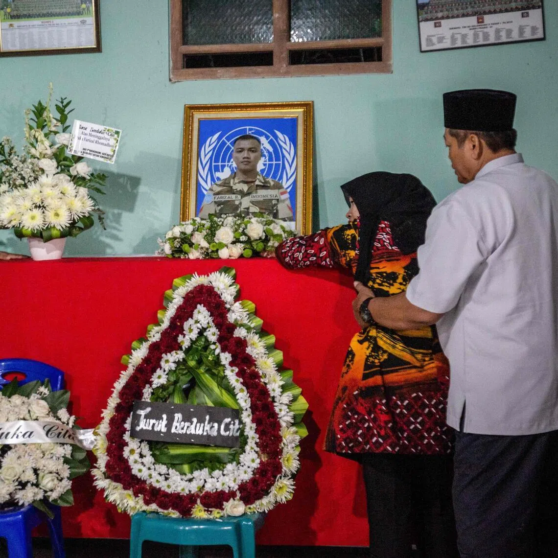 Family members of Indonesian soldier Farizal Rhomadhon mourn beside his coffin at his home in Kulon Progo, Yogyakarta.