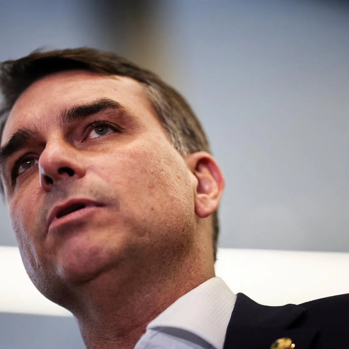 Flavio Bolsonaro speaks with members of the press after a meeting, following a scandal over messages tied to his request for funding for a biopic about former Brazilian President Jair Bolsonaro, from disgraced banker Daniel Vorcaro, who was arrested in March on suspicion of leading a multibillion-dollar fraud scheme, in Brasilia, Brazil, May 19, 2026. REUTERS/Mateus Bonomi