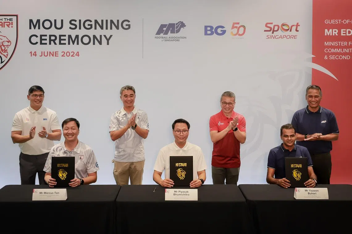 Minister for Culture, Community and Youth Edwin Tong (second from right, standing) at the signing ceremony.