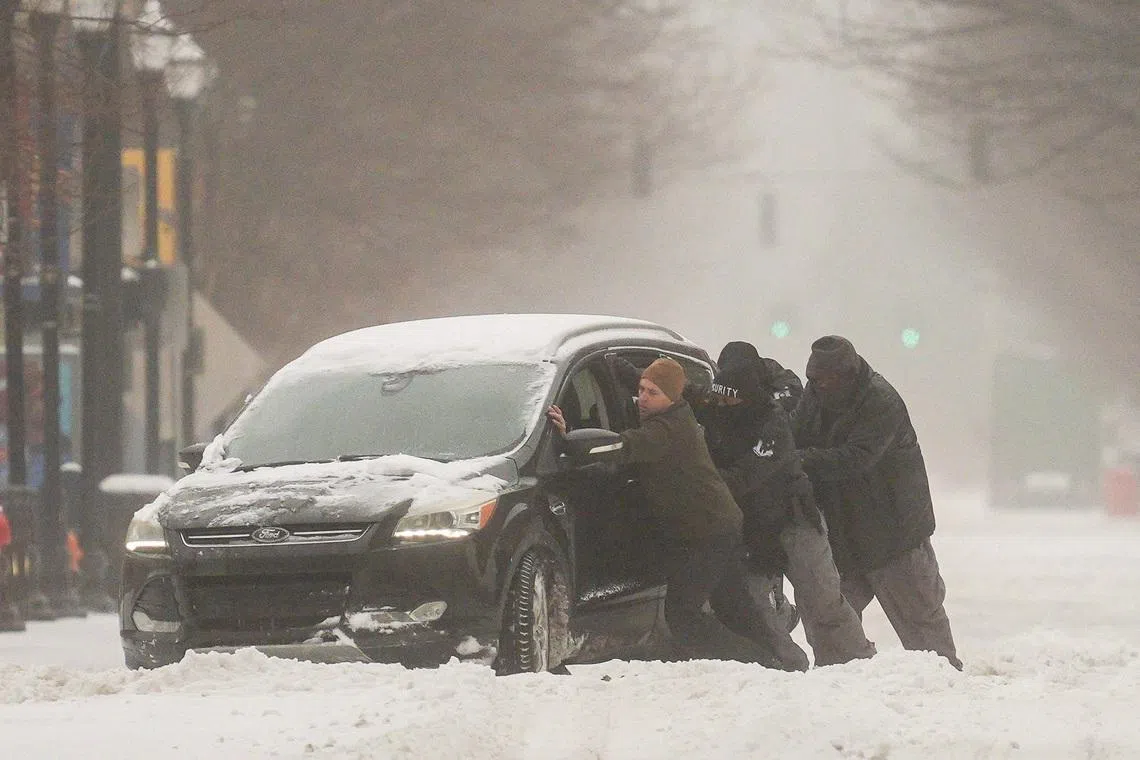 A group of men trying to help a stuck motorist in the snow while the multi-state Winter Storm Fern hits the metro area of Louisville, Kentucky, U.S. on Jan 25, 2026.   