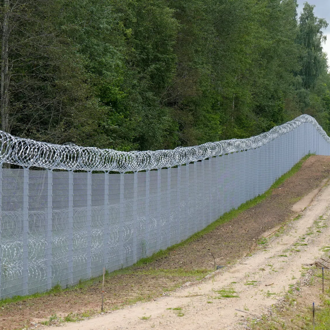 Latvian special unit Border Guard officer patrols along the fence at Latvian-Belarus border near Robeznieki, Latvia August 8, 2023. REUTERS/Ints Kalnins/File Photo