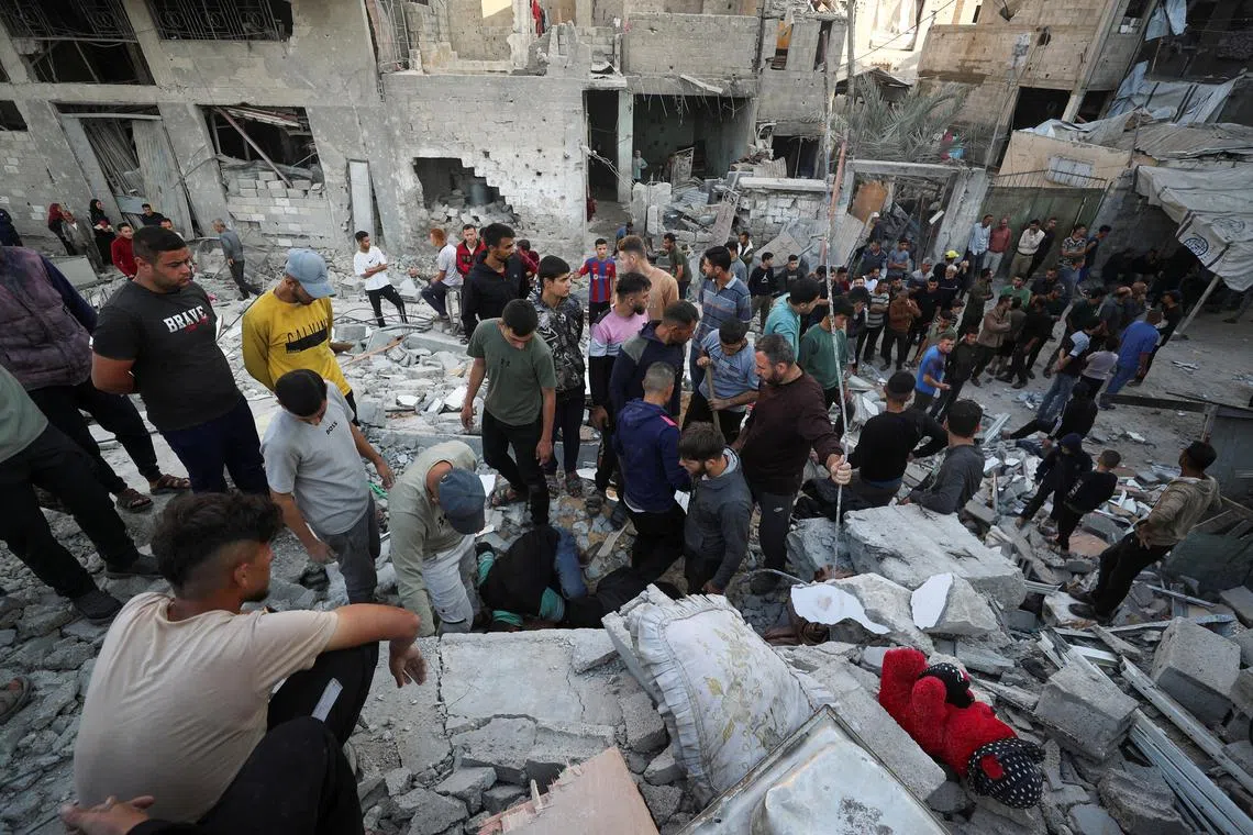 Palestinians gather at the site of an Israeli strike on a house in Jabalia, in the northern Gaza Strip May 23, 2025. REUTERS/Mahmoud Issa