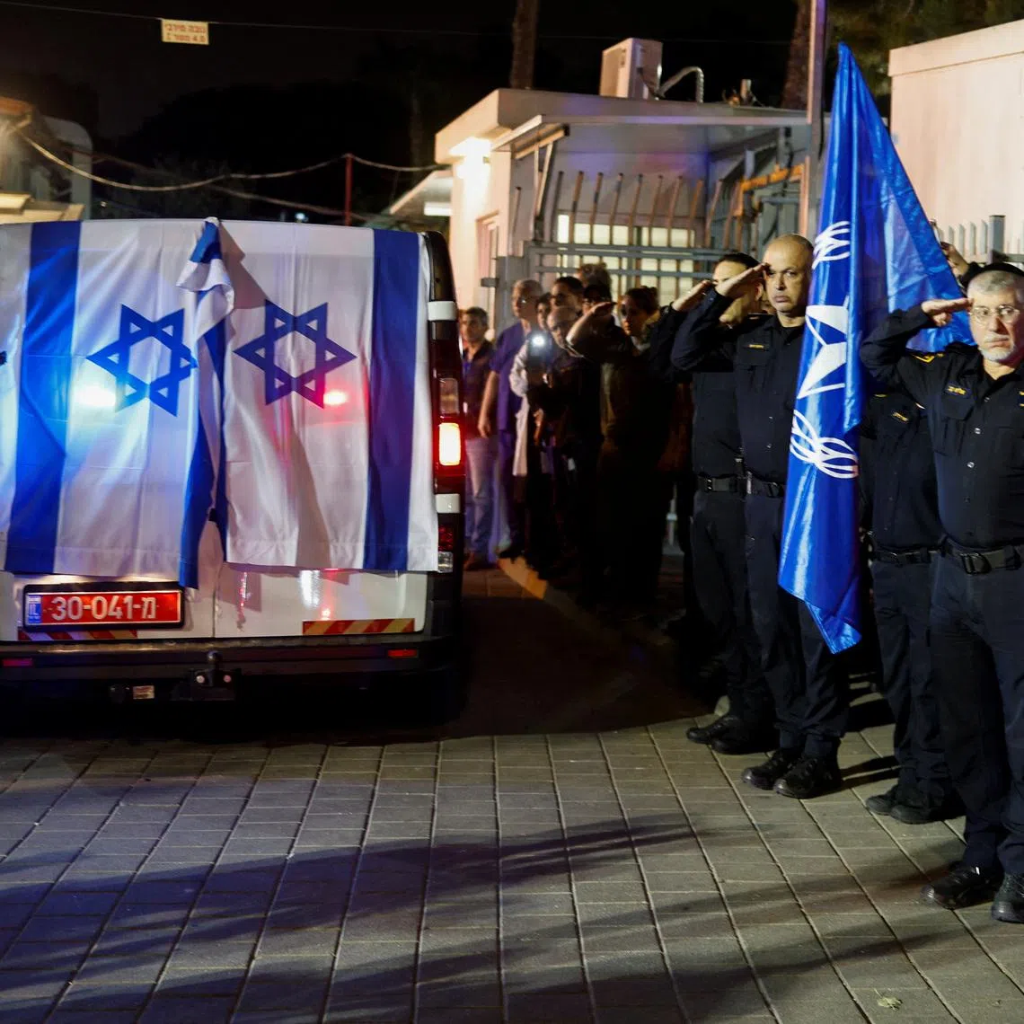 Police officers salute as the vehicle carrying the body of Israeli police officer, and the last hostage Ran Gvili, kidnapped in the October 7, 2023, Hamas attack, arrives to the Institute of Forensic Medicine after being found and identified in the Gaza Strip, according to the statement by the Israeli military, in Tel Aviv, Israel, January 26, 2026. REUTERS/Amir Cohen