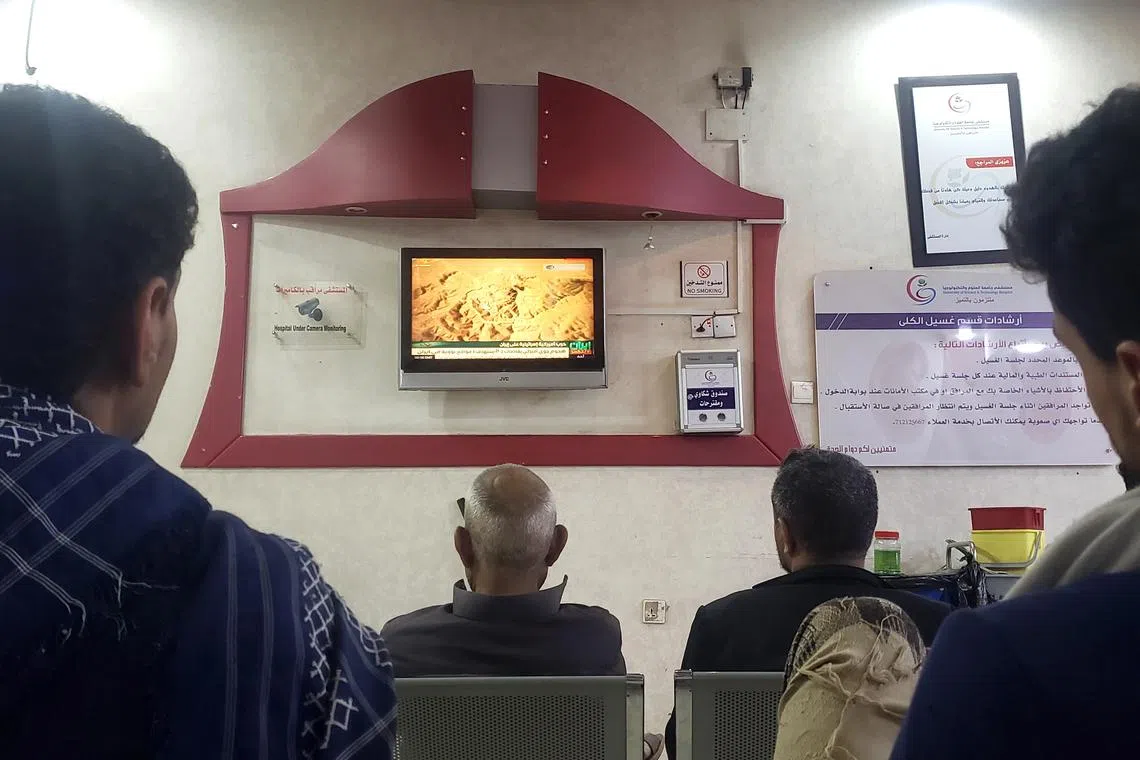 People watching a news broadcast of the US strikes on Iran, in Sanaa, Yemen on June 22.