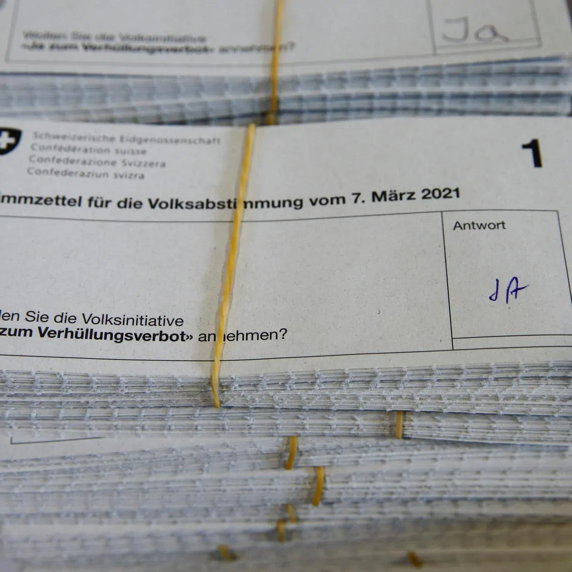Piles of \"Yes\" ballots sit on a table at the district election office Stadtkreis 3 on the day of a Swiss referendum on banning burqas and other facial coverings, in Zurich, Switzerland March 7, 2021. REUTERS/Arnd Wiegmann/File Photo