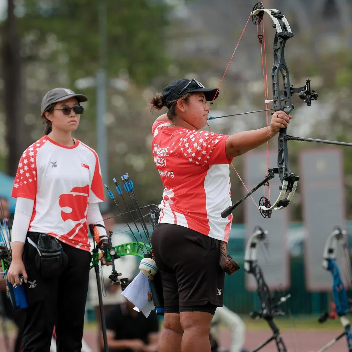 (From right) Singapore's Madeleine Ong wins the SEA Games compound women’s individual gold after teaming up with Jeannice Low and Ellie Low to take silver in the women's team event.