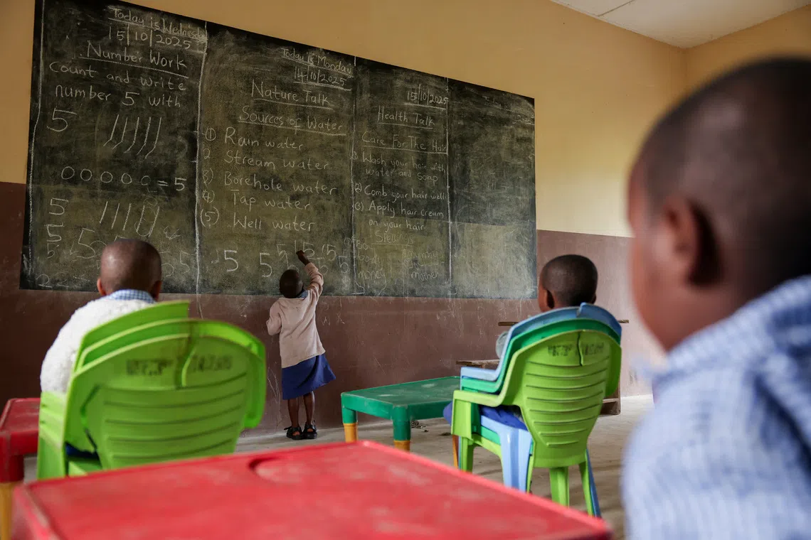A boy accused of witchcraft by his mother writes on a blackboard in a class exercise in Eket, Akwa Ibom state, Nigeria, October 15, 2025. REUTERS/Sodiq Adelakun