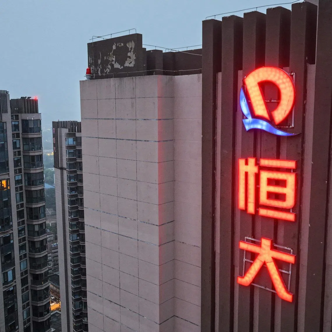 The logo of China Evergrande Group on an apartment buildings in Nanjing, China.  Evergrande’s delisting on Aug 25, 2025, closes a chapter, but China property debt crisis drags on.
