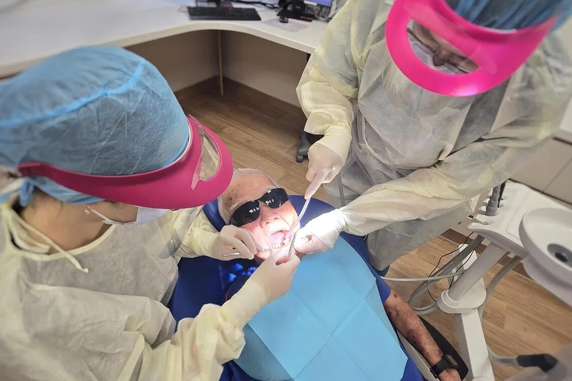Mr Thung Joo Seng having his stitches removed after a front tooth extraction at the dental clinic in NHG Serangoon Polyclinic on April 14.
