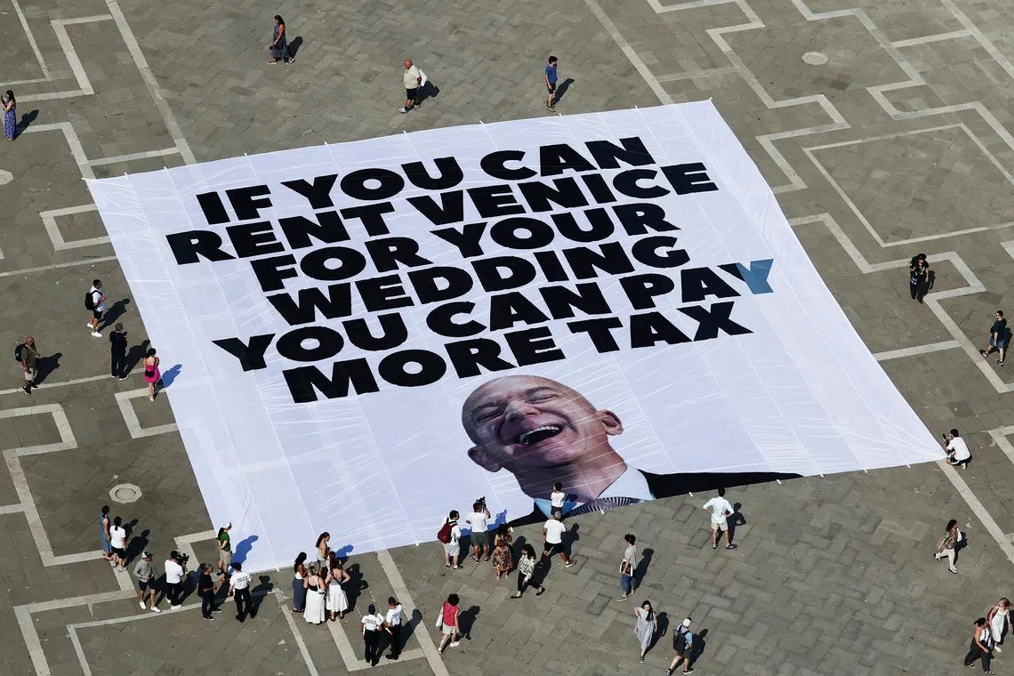 A large banner against Amazon founder Jeff Bezos lies on the ground, placed by Greenpeace Italy activists along with others in St. Mark's Square, ahead of the expected wedding of Amazon founder Jeff Bezos and Lauren Sanchez, in Venice, Italy, June 23, 2025. REUTERS/Yara Nardi