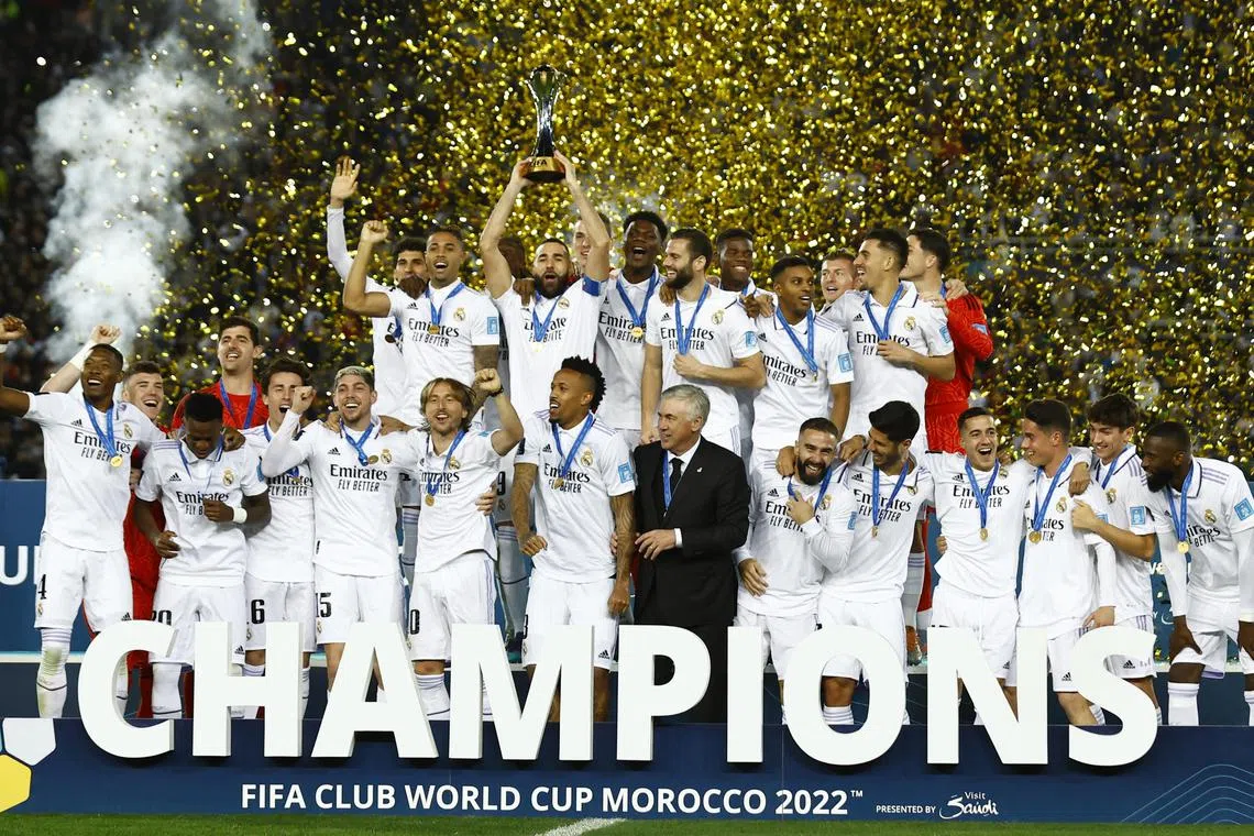 Real Madrid's Karim Benzema lifts the trophy with teammates and coach Carlo Ancelotti after winning the Fifa Club World Cup final.