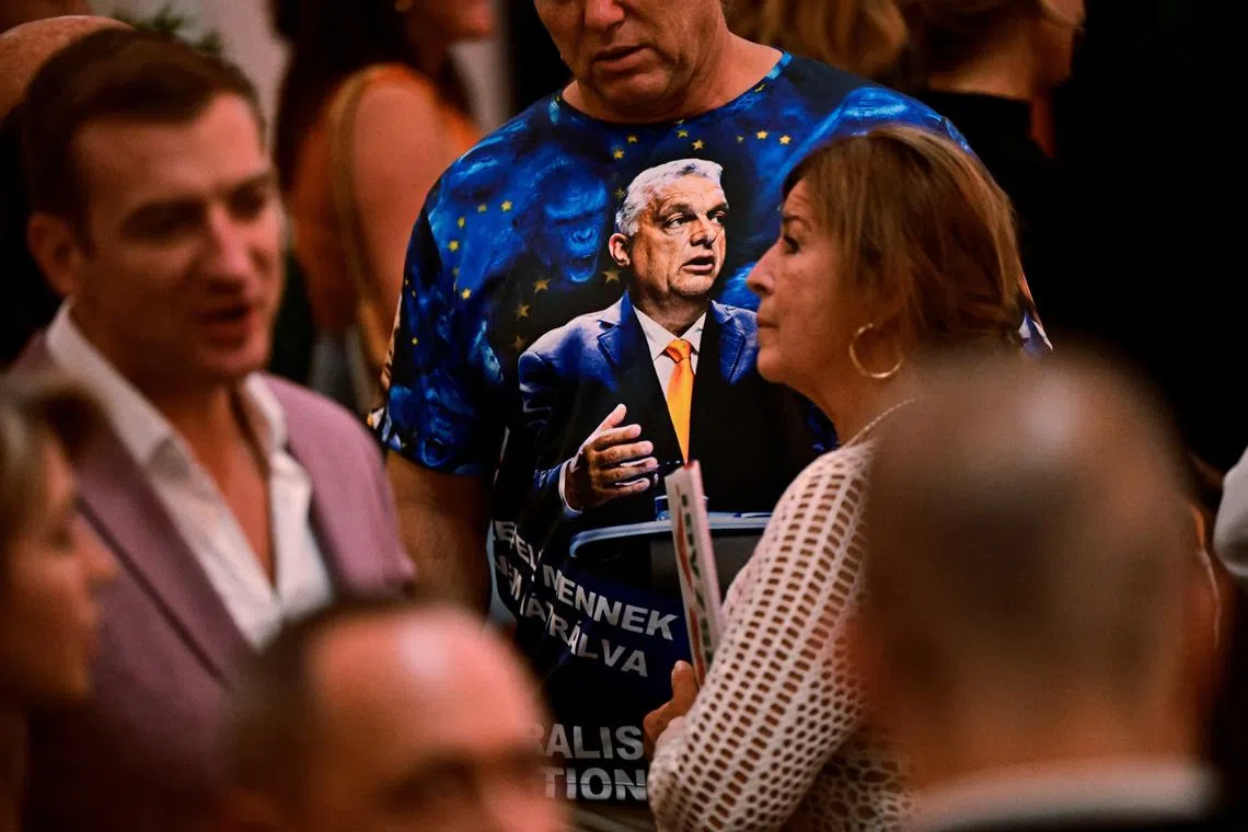 A man wears a T-shirt with an image of Hungarian Prime Minister Viktor Orban as he waits for the prime minister to speak after the announcement of the partial results of the European Parliament and municipal elections, in Budapest, Hungary, June 9, 2024. REUTERS/Marton Monus