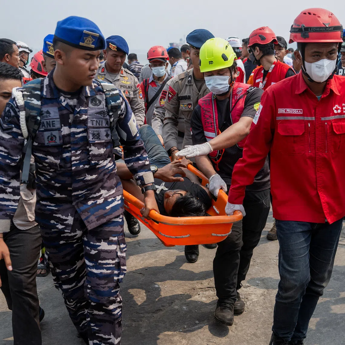 Rescuers using a stretcher carry a passenger of the Virgo Transport 8 ferry that capsized in the Java Sea while sailing from Surabaya in East Java to Banjarmasin in South Kalimantan, upon arrival at Trisakti port in Banjarmasin, South Kalimantan province, Indonesia, September 15, 2026. REUTERS/Stringer