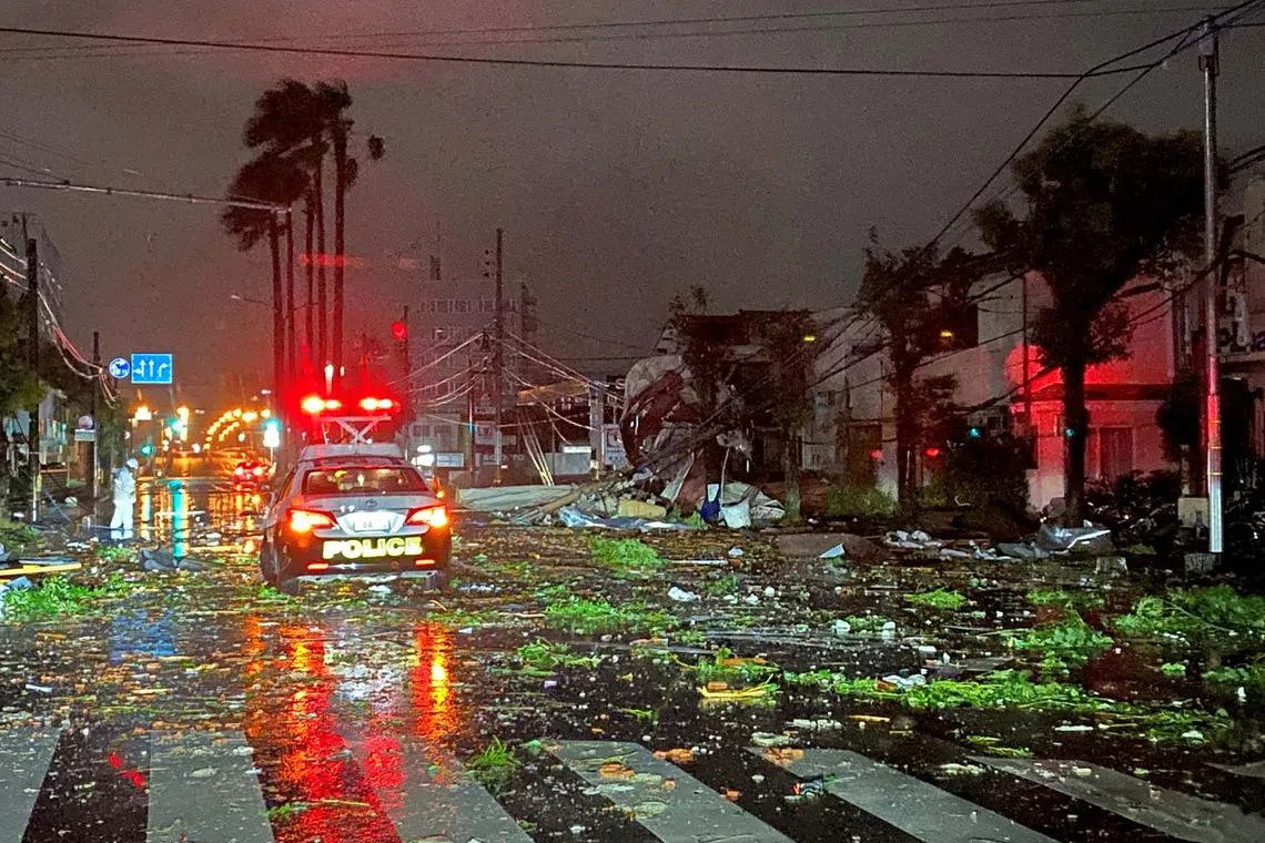 A police car driving amid debris caused by a typhoon in Miyazaki city, Japan Aug 29, 2024.