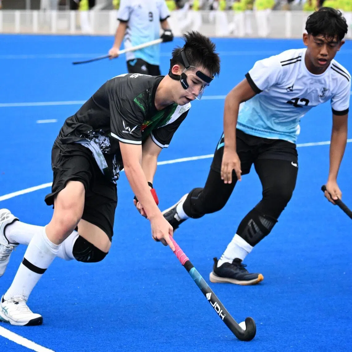 Gabriel Teoh (left) of RI hockey team in action during the National Schools Games hockey B Division boys' final against Sengkang Secondary School on April 20, 2026.