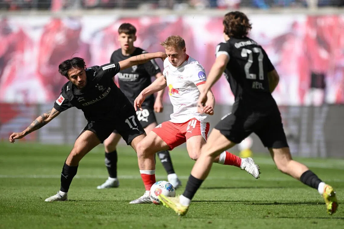 Borussia Moenchengladbach's Jens Castrop closing down RB Leipzig's Xaver Schlager in their Bundesliga game at Red Bull Arena in Leipzig, Germany on April 11, 2026.