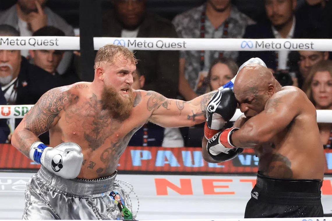 Jake Paul (left) punches Mike Tyson during their heavyweight bout at AT&T Stadium on Nov  15, 2024 in Arlington, Texas.