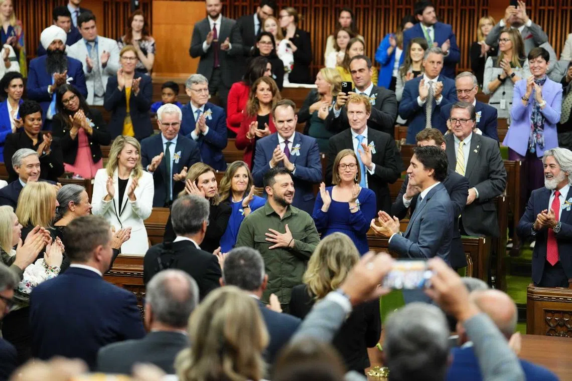 Mr Volodymyr Zelensky (centre), Ukraine's president, receives a standing ovation in Canada's House of Commons, with Justin Trudeau (right), Canada's prime minister.