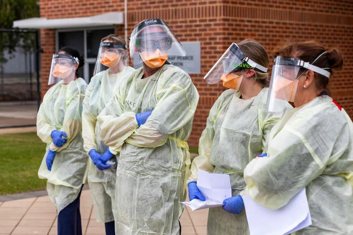 Officials from the Australian Medical Assistance Team and Australian Border Force standing near a plane that transported passengers caught up in the MV Hondius hantavirus outbreak on May 15.
